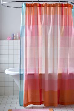 a bathroom with a pink and blue shower curtain