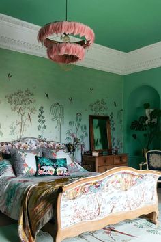 a bed room with a neatly made bed and green walls