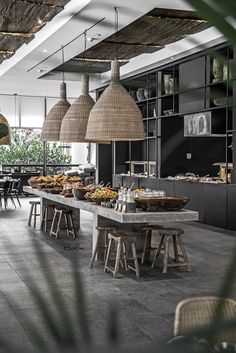 an open kitchen with lots of food on the counter and hanging lights above it,