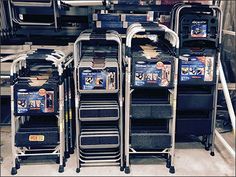 several shopping carts stacked on top of each other in front of a store display case