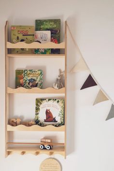 there is a wooden shelf with books on it and a clock next to the shelves