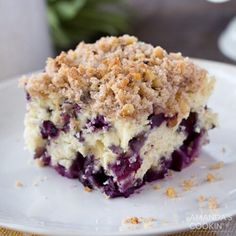 a close up of a piece of cake on a plate with crumbled topping