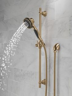 the shower head and handset are shown in this bathroom setting with white marble walls