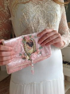 a woman is holding a pink purse with a picture on it