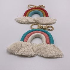 three key chains with tassels on them, one has a rainbow in the middle