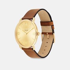 With clean lines and a modern minimalist sensibility the Elliot is a true design classic ready for workdays and weekends. Finished with a leather strap this gold tone round watch features a sunray dial detailed with a mix of numerical and stick makers and our Signature marker at 3 o’clock. | Coach Elliot Watch, 41 Mm - Saddle Classic Gold Watch Accessories With Leather Strap, Timeless Yellow Gold Watches For Work, Timeless Everyday Watch With Round Dial, Classic Yellow Gold Watch Accessories For Everyday, Classic Yellow Gold Watch For Everyday, Classic Yellow Gold Watches For Everyday Wear, Timeless Everyday Watches With Polished Finish, Everyday Timeless Watch With Polished Finish, Minimalist Gold Leather Watch