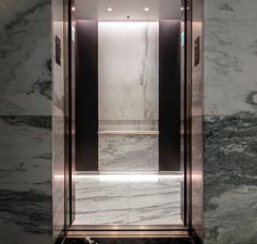 an elevator with marble walls and flooring