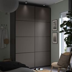 an open closet with clothes and shoes on the floor next to a bed in a room