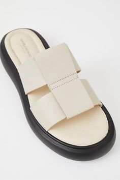 Vagabond woven look Blenda slide in black leather. Slip-on, rounded toe and sole. 40mm heel height. Goat leather upper, Pu outsole, goat leather lining, cow leather inner sole. This style is made by DIAMOND TREASURE LTD LONG AN PROVINCE, VIETNAM. 5519-201-02 PIPE AND ROW Off White Slides, White Slides Sandals, Vagabond Shoes, Neutral Shoes, Cream Shoes, Shoe Horn, Shoe Last, Goat Leather, Womens Sandals Flat