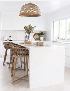 an island in the middle of a white kitchen