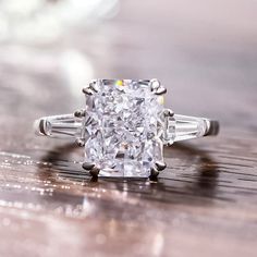 an old - fashioned diamond ring sits on a wooden surface