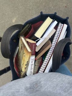 a person holding a bag full of books