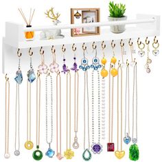 a white shelf filled with lots of different colored necklaces and earrings hanging from it's sides