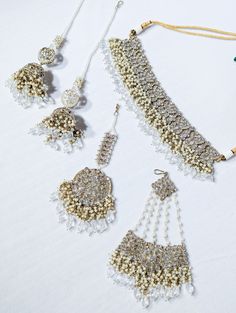 A semi-Indian bridal set is a stunning and elegant jewelry ensemble that beautifully combines elements of traditional Indian craftsmanship with modern design sensibilities. This exquisite set is designed for brides who wish to strike a perfect balance between traditional and contemporary aesthetics on their special day. The semi-Indian bridal set typically includes a harmonious combination of statement necklaces, earrings, tikka, and jummar all carefully crafted with intricate detailing and luxu Statement Necklaces, Bride Style, Traditional Indian, Bridal Set, Indian Bridal, Wedding Attire, Elegant Jewelry, Bridal Sets, Semi Precious Gemstones