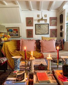 a living room filled with lots of books and candles on top of a coffee table