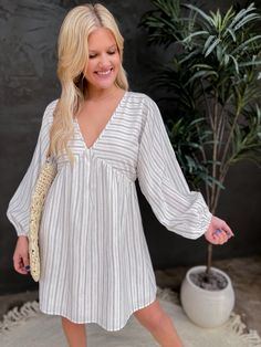 A balloon long-sleeve empire line dress with a tie in the back. Runs true to size. Model is wearing an XSmall (32” bust, 26” waist, 35” hips, 5’2”) Bust Waist Length Sleeve Length XSmall 30 inches 40 inches 32 inches 25 inches Small 32 inches 42 inches 33 inches 25 inches Medium 34 inches 44 inches 33 inches 26 inches Large 36 inches 46 inches 34 inches 26 inches We measure each item from side seam to side seam, on a flat surface. Please consider the fabric content of each item, as fabric contai Long Sleeve Dresses With Blouson Sleeves For Vacation, Vacation Long Sleeve Dress With Blouson Sleeves, Flowy Long Sleeve Dress With Gathered Sleeves, Dresses With Elastic Lantern Sleeves For Day Out, Lantern Sleeve Dresses With Elastic Sleeves For Day Out, Day Out Dresses With Lantern Elastic Sleeves, Lantern Sleeve Dress With Elastic Sleeves For Day Out, Long Sleeve Dress With Gathered Sleeves For Beach, White Long Sleeve Mini Dress With Elastic Sleeves