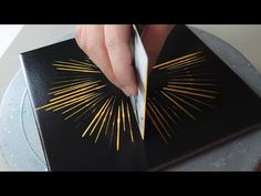 someone is cutting into a black and gold book