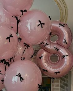 pink balloons with black bows are arranged in the shape of an eight - letter balloon