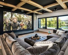 a living room filled with furniture and a large screen tv mounted to the side of a wall