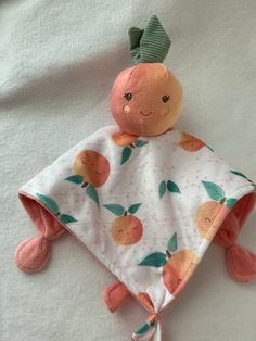 an orange stuffed animal laying on top of a white bed next to a green headband