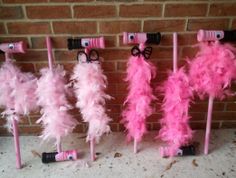 pink and white feathers are on sticks with eyeglasses in the shape of letters