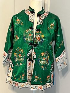 This beautiful kimono robe was brought back from China in the 1980's.  It is hand embroidered and a beautiful green color.  It is lined in a beautiful blue silk. The robe is photographed on a Medium size 10-12 women's dress form - it is labeled size Large, but it runs small by current standards.  I'd say its a roomy Medium, or size 12. 100% silk, it hangs beautifully. Green Embroidered Kimono With Kimono Sleeves, Spring Silk Kimono With Embroidery, Silk Kimono With Floral Embroidery, Spring Embroidered Silk Kimono, Green Kimono With Kimono Sleeves For Tea Ceremony, Traditional Embroidered Kimono For Tea Ceremony, Traditional Green Kimono For Spring, Traditional Embroidered Silk Kimono, Traditional Green Long Sleeve Robe