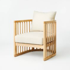 a wooden chair with a white pillow on it's back and armrests