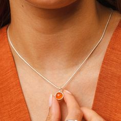 Bring harmony to your everyday look with this orange agate touchstone necklace. Designed with an open sunrise back to allow the stone to sit close to you when worn, this necklace looks stunning from all angles. The spiritual use of healing stones has been around for centuries with each stone believed to radiate its own natural energies to help create balance. Shimmering with deep orange hues the orange agate healing stone hangs beautifully from our slim snake chain and inspires emotional balance Everyday Spiritual Orange Jewelry, Orange Pendant Necklace With Birthstone, Orange Birthstone Pendant Necklace, Orange Round Pendant Necklace, Orange Gemstone Oval Pendant Necklace, Orange Carnelian Necklace With Round Pendant, Healing Stones Jewelry, Healing Stones Necklace, Orange Hues