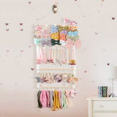 a baby's room with hearts on the wall and a hanging rack for hair accessories