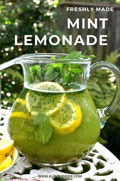 a pitcher filled with lemonade sitting on top of a table