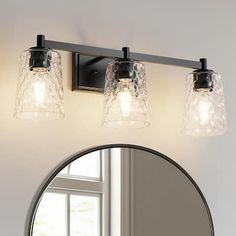 a bathroom vanity with three lights and a mirror