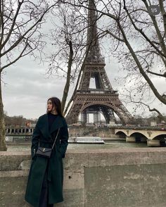 a woman standing in front of the eiffel tower