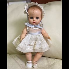 a baby doll sitting on top of a white couch