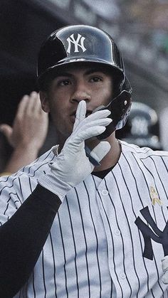 a baseball player is holding his hand up to his mouth