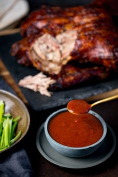 a plate with meat and vegetables on it next to a bowl of ketchup