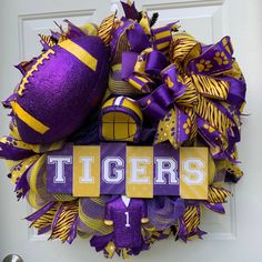 a purple and yellow wreath with the word tigers on it, hanging from a door