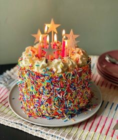 a birthday cake with sprinkles and lit candles