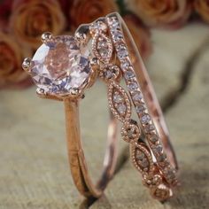 two gold rings with pink and white diamonds on them, one has an oval shaped morganite in the center