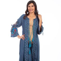 Denim Duster. This Bold Maxi Denim Duster Features Colorful Dream Catcher Embroidery On The Sleeves With Denim Band Ties At The Elbow. Geometric Embroidered Bands Run Down The Placket And Around The Neck, And Have A Tassel Tie Front Closure. Import. Hand Wash Separately In Cold Water Or Dry Clean Recommended.. Bohemian Medium Wash Long Sleeve Outerwear, Bohemian Dark Wash Denim Jacket For Spring, Bohemian Long Sleeve Outerwear In Medium Wash, Bohemian Long Sleeve Medium Wash Outerwear, Bohemian Blue Denim Jacket With Pockets, Bohemian Blue Denim Top, Bohemian Summer Denim Jacket In Medium Wash, Bohemian Blue Denim Jacket For Fall, Bohemian Dark Wash Outerwear For Spring