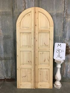 an old wooden door is next to a white vase with a sign that says m & o