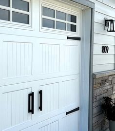 a white garage door with black handles on it