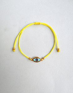 Martis bracelet, Evil eye bracelet Gold enamel charm, Waxed cord March bracelets, Red and White, Twisted string, Greek Tradition Unisex gift The March bracelet is an ancient Greek custom. From the beginning of March, people wear a bracelet made of white and red twisted thread. According to the tradition, the March bracelet protects those from burning of the first sun of spring. The last day of March,the bracelet is left on trees so that swallows can use it for building their nests. Bracelet is m Gold Nylon Cord Friendship Bracelets As Gift, Gold Braided Evil Eye Bracelet As A Gift, Gold Braided Bracelet With Evil Eye For Gift, Gold Braided Bracelet With Evil Eye As Gift, Yellow Adjustable Cord Bracelet, Adjustable Yellow Braided Bracelets As Gift, Yellow Resizable Jewelry For Friendship, Gold Evil Eye Bracelet With Sliding Knot As Gift, Yellow Adjustable Friendship Bracelets As Gift