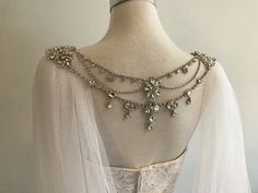 the back of a wedding dress with beading and pearls on it's neck