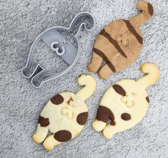 three cookie cutters shaped like cats and dogs on the ground next to each other