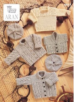 there are many knitted sweaters and hats on the wooden floor with other items