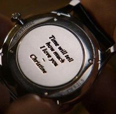 a person holding onto a wrist watch with the words happy birthday written on its dial