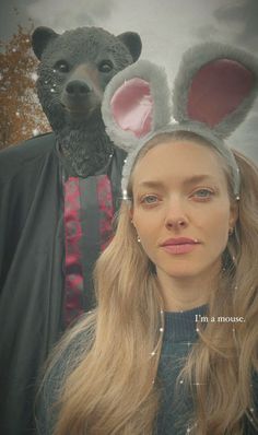 a woman standing next to a man wearing bunny ears