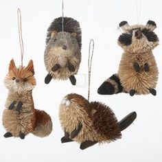 four stuffed animals hanging from strings in the shape of raccoon's heads