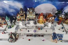 a christmas village is displayed in front of a backdrop