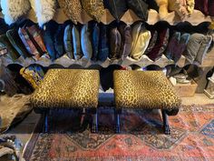 leopard print foot stools in front of a rack of jackets and scarves on display